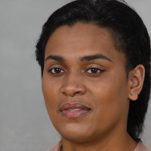 Joyful black young-adult female with short  black hair and brown eyes