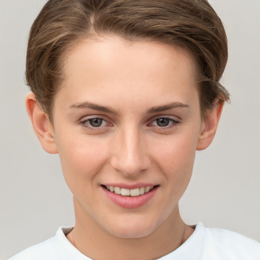 Joyful white young-adult female with short  brown hair and grey eyes