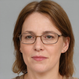 Joyful white adult female with medium  brown hair and blue eyes