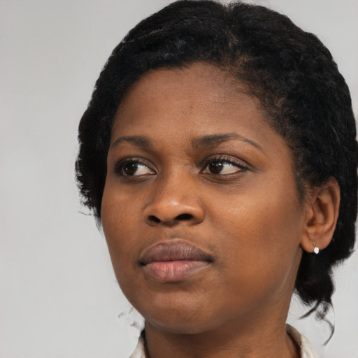 Joyful black young-adult female with short  black hair and brown eyes