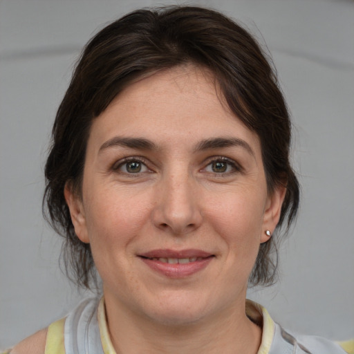 Joyful white young-adult female with medium  brown hair and grey eyes