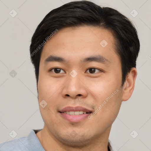 Joyful asian young-adult male with short  brown hair and brown eyes