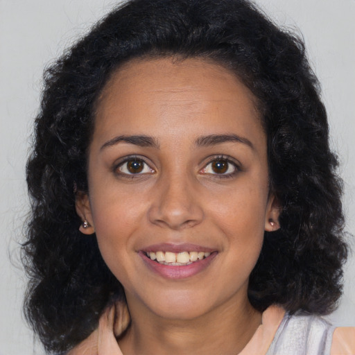 Joyful latino young-adult female with long  brown hair and brown eyes