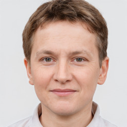 Joyful white young-adult male with short  brown hair and grey eyes