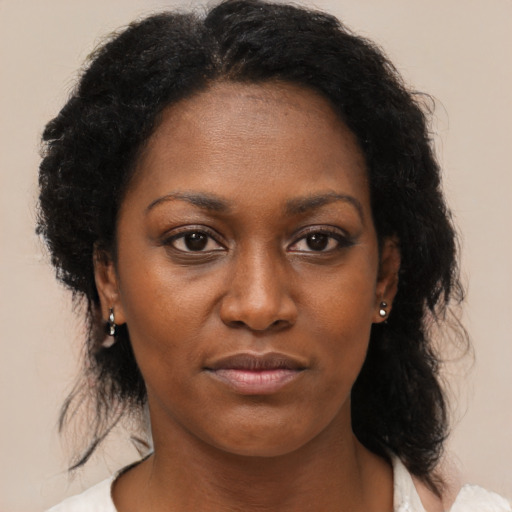 Joyful black young-adult female with medium  brown hair and brown eyes