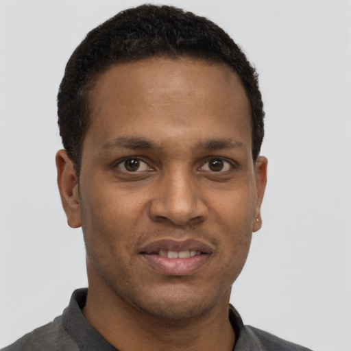 Joyful black young-adult male with short  black hair and brown eyes