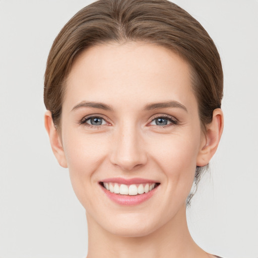 Joyful white young-adult female with short  brown hair and grey eyes