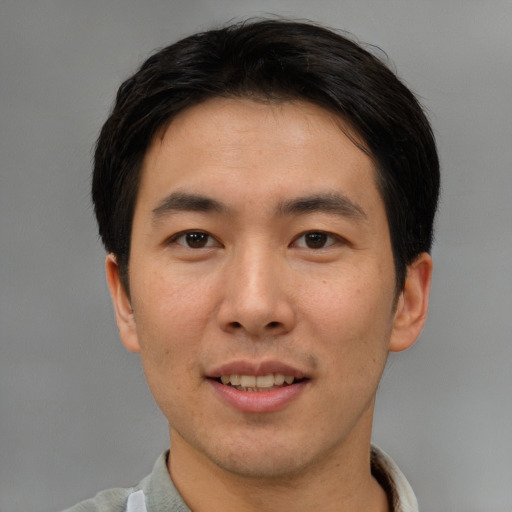 Joyful asian young-adult male with short  brown hair and brown eyes