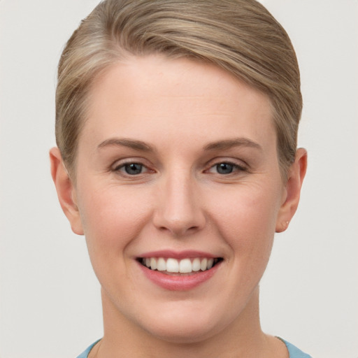 Joyful white young-adult female with short  brown hair and grey eyes