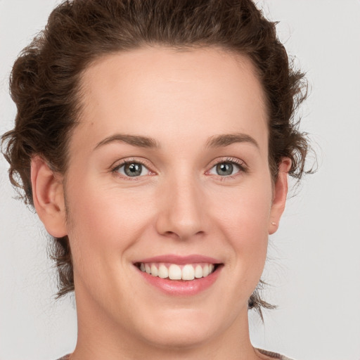 Joyful white young-adult female with medium  brown hair and green eyes