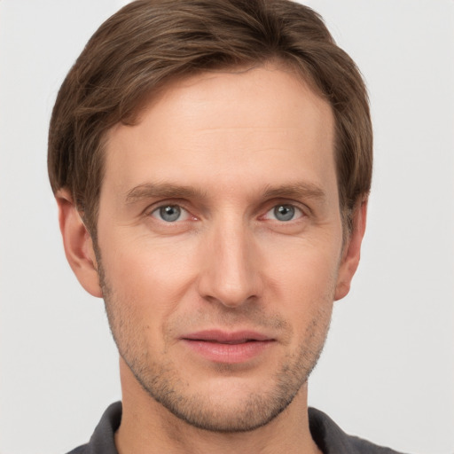 Joyful white young-adult male with short  brown hair and grey eyes