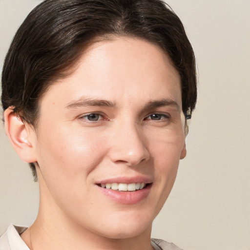 Joyful white young-adult female with short  brown hair and grey eyes