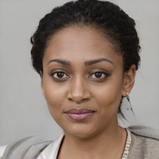 Joyful black young-adult female with short  brown hair and brown eyes
