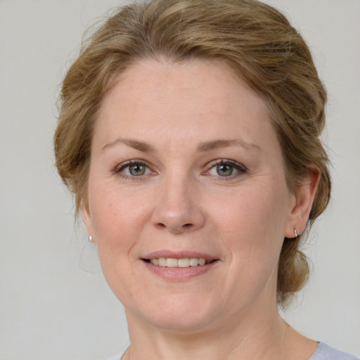 Joyful white adult female with medium  brown hair and green eyes