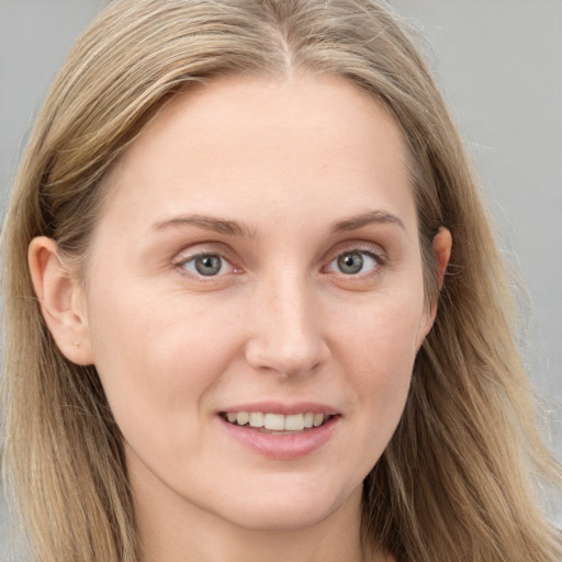 Joyful white young-adult female with long  brown hair and blue eyes