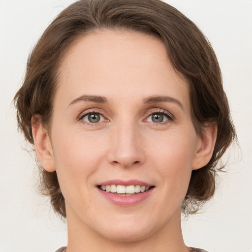 Joyful white young-adult female with medium  brown hair and green eyes