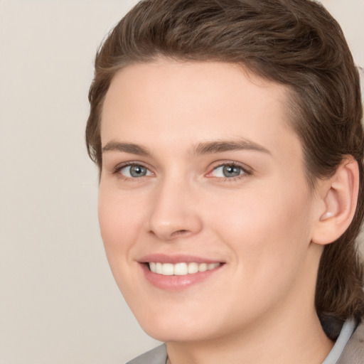 Joyful white young-adult female with medium  brown hair and grey eyes