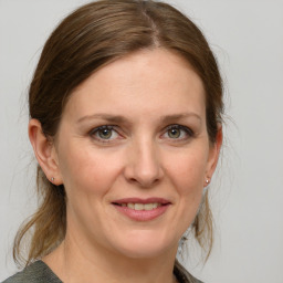 Joyful white adult female with medium  brown hair and grey eyes