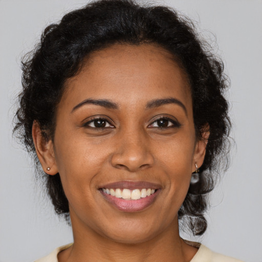 Joyful black young-adult female with medium  brown hair and brown eyes