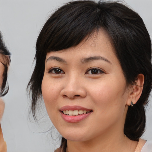 Joyful asian young-adult female with medium  brown hair and brown eyes