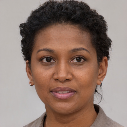 Joyful black young-adult female with short  brown hair and brown eyes