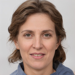 Joyful white adult female with medium  brown hair and grey eyes