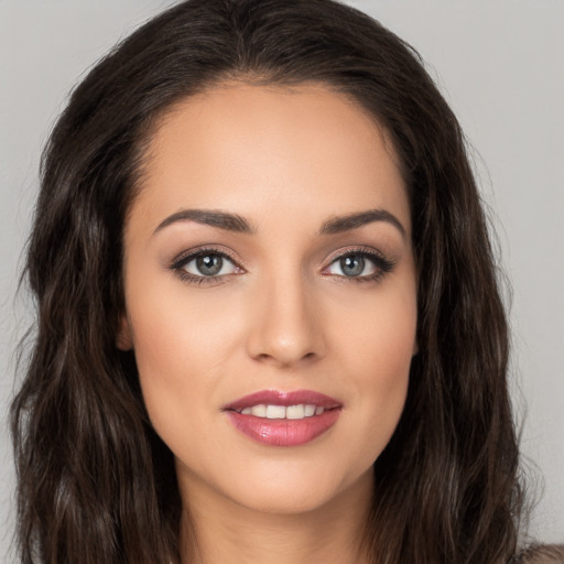 Joyful white young-adult female with long  brown hair and brown eyes