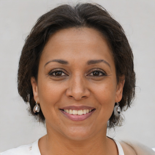 Joyful latino adult female with medium  brown hair and brown eyes