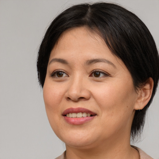 Joyful asian adult female with medium  brown hair and brown eyes