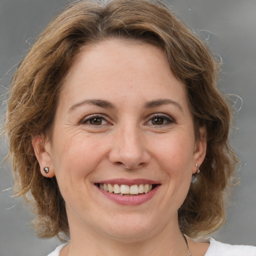 Joyful white adult female with medium  brown hair and brown eyes