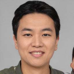 Joyful asian young-adult male with short  black hair and brown eyes