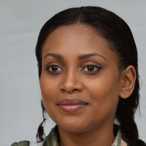 Joyful black young-adult female with long  brown hair and brown eyes