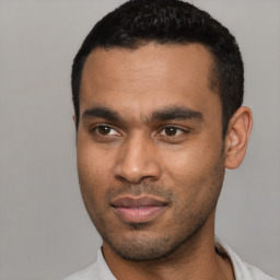 Joyful latino young-adult male with short  black hair and brown eyes