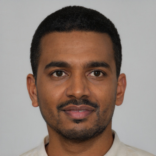 Joyful black young-adult male with short  black hair and brown eyes