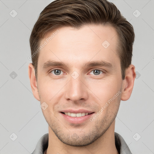 Joyful white young-adult male with short  brown hair and grey eyes