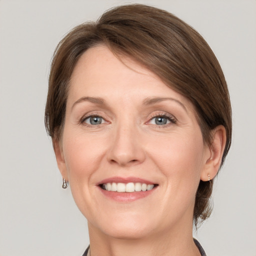 Joyful white adult female with medium  brown hair and grey eyes