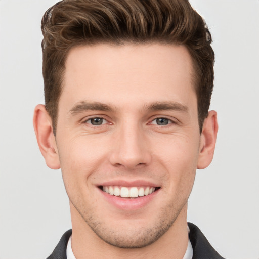 Joyful white young-adult male with short  brown hair and grey eyes