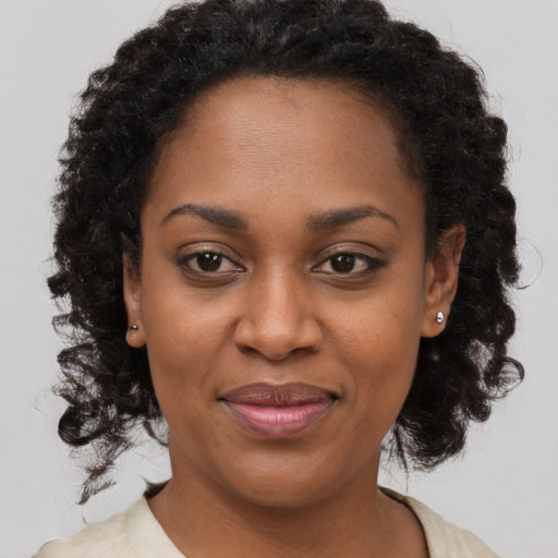 Joyful black adult female with long  brown hair and brown eyes