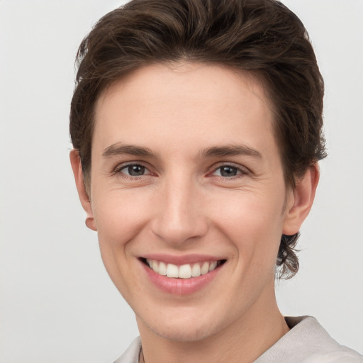 Joyful white young-adult female with short  brown hair and grey eyes