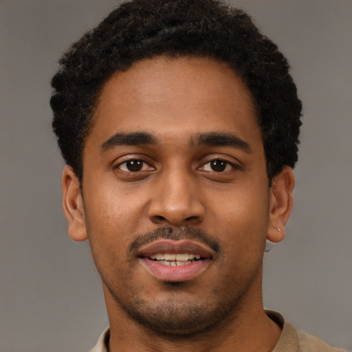 Joyful black young-adult male with short  black hair and brown eyes