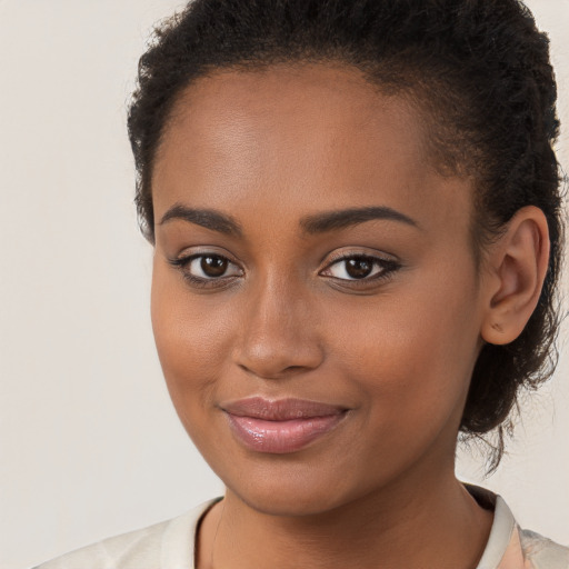 Joyful black young-adult female with long  brown hair and brown eyes