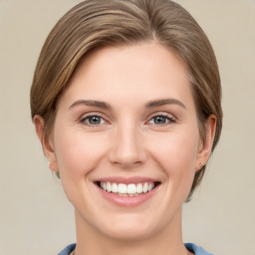 Joyful white young-adult female with medium  brown hair and grey eyes