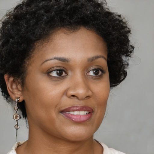 Joyful black young-adult female with medium  brown hair and brown eyes