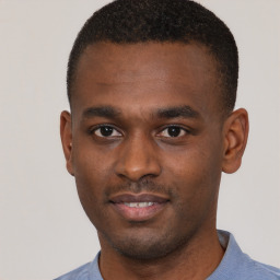 Joyful black young-adult male with short  brown hair and brown eyes