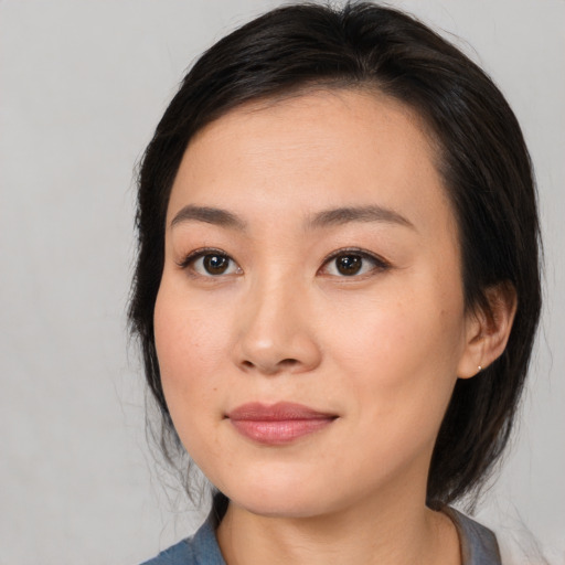 Joyful asian young-adult female with medium  brown hair and brown eyes