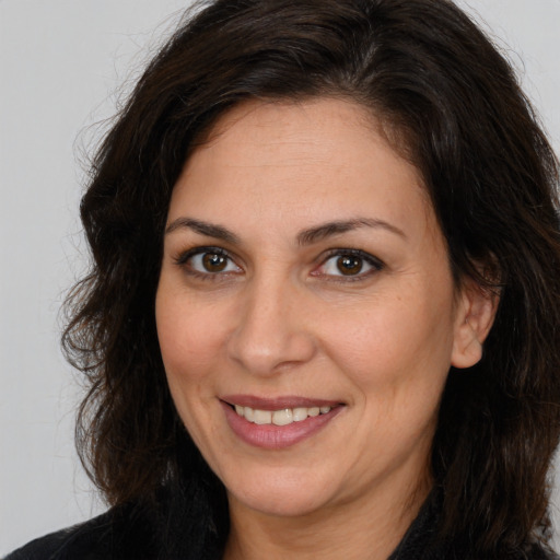Joyful white adult female with long  brown hair and brown eyes