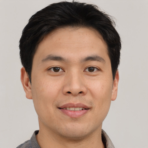Joyful asian young-adult male with short  brown hair and brown eyes