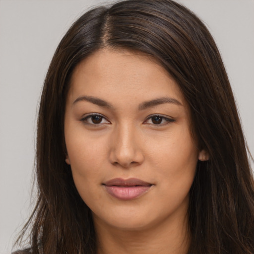 Joyful latino young-adult female with long  brown hair and brown eyes