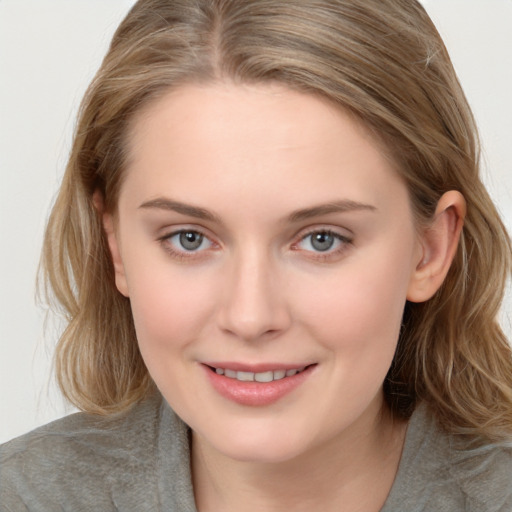 Joyful white young-adult female with long  brown hair and blue eyes