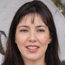 Joyful white adult female with long  brown hair and brown eyes